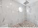 Gorgeous shower with marble wall tile, a round window, mosaic floor, and a rain shower head at 9722 Tiffany Oaks Ln, Tampa, FL 33612