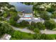 Stunning aerial view of a community clubhouse with a pool, tennis courts, and a scenic lake with a fountain at 10820 Hachita Dr, Port Richey, FL 34668