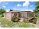 Backyard featuring a sunroom, healthy grass, and mature landscaping at 10820 Hachita Dr, Port Richey, FL 34668