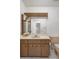 Bathroom vanity featuring wood cabinets and a large mirror, with toilet shown to the right at 10820 Hachita Dr, Port Richey, FL 34668
