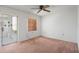 Bedroom with neutral walls, plush carpeting, bright light from attached Florida room, and a ceiling fan at 10820 Hachita Dr, Port Richey, FL 34668