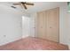 Bedroom with large closet, ceiling fan, and pink carpet, offering comfort and ample storage space at 10820 Hachita Dr, Port Richey, FL 34668