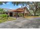 Clubhouse entrance featuring a covered walkway, landscaping, and architectural details for a welcoming community space at 10820 Hachita Dr, Port Richey, FL 34668