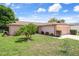 Charming single-story home featuring an attached garage, well-maintained lawn, and mature landscaping at 10820 Hachita Dr, Port Richey, FL 34668