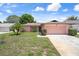 Charming single-story home featuring an attached garage, well-maintained lawn, and lovely landscaping at 10820 Hachita Dr, Port Richey, FL 34668
