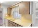 Kitchen showcasing yellow countertops, wood cabinets, and a modern sink at 10820 Hachita Dr, Port Richey, FL 34668