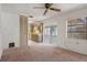 Bright living room featuring plush carpeting, a ceiling fan, and sliding glass doors to Florida room at 10820 Hachita Dr, Port Richey, FL 34668