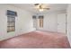 Spacious main bedroom with three windows for natural light, plush carpet, and a ceiling fan at 10820 Hachita Dr, Port Richey, FL 34668