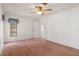 Main bedroom with a window, neutral walls, plush carpeting, and a ceiling fan with light at 10820 Hachita Dr, Port Richey, FL 34668