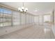 Open sunroom with white tile flooring, light fixture, and many windows providing ample light at 10820 Hachita Dr, Port Richey, FL 34668