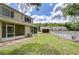 A spacious green backyard featuring a white fence, screened-in porch, and view of the community pool at 11304 Cayman Key Ave # 2, Tampa, FL 33624
