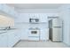 Bright kitchen featuring white cabinets, stainless steel appliances, and tile flooring at 11304 Cayman Key Ave # 2, Tampa, FL 33624
