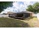 View of the home's backyard featuring a screened patio, a well-maintained lawn, and privacy fencing at 11416 Wellman Dr, Riverview, FL 33578