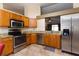 A kitchen featuring stainless steel appliances, granite countertops, and natural wood cabinets at 11416 Wellman Dr, Riverview, FL 33578