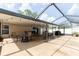Wide shot of a covered patio with chairs, tables, a grill, string lights, and exterior access at 11416 Wellman Dr, Riverview, FL 33578