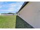 Side yard featuring verdant grass, an exterior wall, and partial backyard view at 12055 Cardinal Flower Dr, Riverview, FL 33579