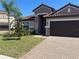 Inviting home with a brick driveway, two-car garage, and mature landscaping at 12055 Cardinal Flower Dr, Riverview, FL 33579