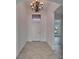 Bright entryway featuring tile floors, a decorative chandelier, and a view of an adjacent room at 12055 Cardinal Flower Dr, Riverview, FL 33579