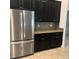 Kitchen featuring stainless steel refrigerator, dark cabinets, granite counters, decorative backsplash and tile flooring at 12055 Cardinal Flower Dr, Riverview, FL 33579