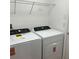 Efficient laundry room featuring a side-by-side washer and dryer and a wire shelf for storage at 12055 Cardinal Flower Dr, Riverview, FL 33579