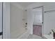 White tiled shower and tub combo with a view to wood floors and a double door entry at 12055 Cardinal Flower Dr, Riverview, FL 33579