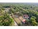 Beautiful aerial view of a large property with mature trees, featuring a home, barn, and pool at 12311 Oakwood Dr, Hudson, FL 34669
