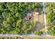Bird's eye view of a property featuring a house with a pool, barn and flourishing greenery, creating a peaceful oasis at 12311 Oakwood Dr, Hudson, FL 34669
