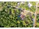 Overhead view showcases a property featuring a home, a barn and in-ground pool, nestled amidst lush greenery at 12311 Oakwood Dr, Hudson, FL 34669