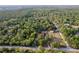 Majestic aerial view of a peaceful property with a charming home, a barn and refreshing pool surrounded by verdant trees at 12311 Oakwood Dr, Hudson, FL 34669