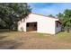 White barn with a red roof, situated in a grassy field, providing ample space for animals at 12311 Oakwood Dr, Hudson, FL 34669