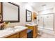 Bathroom featuring dual vanities, tiled floor, and a shower with glass doors at 12311 Oakwood Dr, Hudson, FL 34669