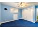 A comfortable bedroom featuring a ceiling fan, closet, and a charming blue color scheme at 12311 Oakwood Dr, Hudson, FL 34669