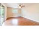 Bright bedroom featuring beautiful laminate floors, a ceiling fan, and access to the outdoors at 12311 Oakwood Dr, Hudson, FL 34669