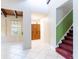 Bright entryway features tile floors, wooden doors, and a staircase with a green accent wall at 12311 Oakwood Dr, Hudson, FL 34669