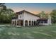 Expansive stucco home with arched loggia, covered balcony, and a lush lawn against wooded backdrop at 12311 Oakwood Dr, Hudson, FL 34669
