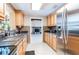 Functional kitchen boasts wood cabinets, modern appliances, and an adjoining living area with a cozy fireplace at 12311 Oakwood Dr, Hudson, FL 34669