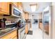Classic kitchen with oak cabinets, stainless steel appliances, tile backsplash, and open layout to dining area at 12311 Oakwood Dr, Hudson, FL 34669