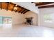 Spacious living room with a stone fireplace and beautiful wood beamed vaulted ceilings at 12311 Oakwood Dr, Hudson, FL 34669