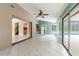 Bright living area with tile flooring, ceiling fan, and sliding glass doors leading to the pool at 12311 Oakwood Dr, Hudson, FL 34669
