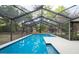 Inviting in-ground pool enclosed with screen, offering a relaxing backyard retreat at 12311 Oakwood Dr, Hudson, FL 34669