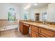 Bathroom featuring double sinks with granite countertops and arched window with tub at 12421 Seabrook Dr, Tampa, FL 33626