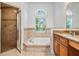Bathroom featuring granite counters, tiled shower, and tub with an arched window at 12421 Seabrook Dr, Tampa, FL 33626