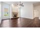 Bright living space with hardwood floors, a ceiling fan, and a decorative fireplace with windows on either side at 12421 Seabrook Dr, Tampa, FL 33626