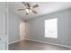 This bedroom features a ceiling fan, window, and gray wood-style flooring at 1250 Charlesworth Dr, Wesley Chapel, FL 33543