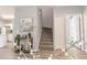 Bright entryway featuring a staircase, modern decor, and a view to the kitchen and secondary room at 1250 Charlesworth Dr, Wesley Chapel, FL 33543
