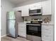 Bright kitchen features stainless steel appliances, white cabinets and countertops at 1250 Charlesworth Dr, Wesley Chapel, FL 33543