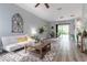 Bright, open-concept living room with wood floors, a comfortable couch, and lots of natural light at 1250 Charlesworth Dr, Wesley Chapel, FL 33543