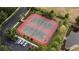 Aerial view of the community tennis courts with updated resurfacing, nearby pond, and parking at 1250 Charlesworth Dr, Wesley Chapel, FL 33543