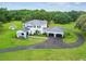 Aerial view of two-story white home with metal roof, long driveway, and large lot at 13711 Lussier Ln, Spring Hill, FL 34610
