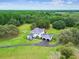 Expansive aerial view of two-story white home on manicured lot, with long driveway at 13711 Lussier Ln, Spring Hill, FL 34610
